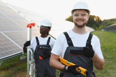 Çeşitli mühendislik ekipleri güneş panelleri kuruyor, yenilenebilir enerji ve sürdürülebilir enerji üretimine odaklanıyor