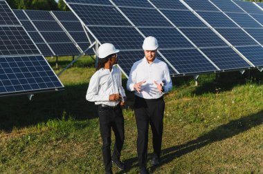 Çeşitli mühendisler yenilenebilir enerji ve sürdürülebilir elektrik enerjisi üzerine yoğunlaşan geniş bir güneş paneli dizisi üzerinde çalışıyorlar.