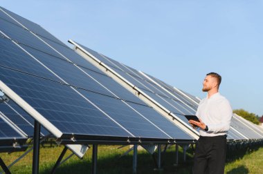 Güneş paneli kurulumları için dijital tablet kullanan mühendis yenilenebilir enerji üretiminde verimlilik sağlıyor