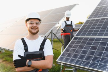 Mutlu mühendis güneş enerjisi santralinde çalışıyor, sürdürülebilir yeşil enerji ve temiz elektrik sağlıyor.
