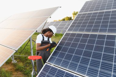 Afrikalı Amerikalı teknisyen fotovoltaik hücreler kuruyor, temiz enerji üretimi ve sürdürülebilir güç çözümleri sağlıyor