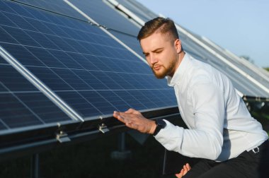 Mühendis güneş panelini kontrol ediyor, etkin bir çalışma sağlanıyor. Yenilenebilir enerji ve sürdürülebilir teknoloji üzerine yoğunlaşmak