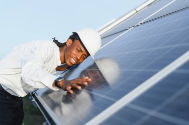 Mühendis güneş panellerini kontrol ediyor, sürdürülebilir enerji üretimini ve temiz elektrik üretimini sağlıyor. Yenilenebilir güç teknolojisine odaklan.