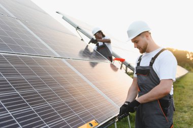 Mühendisler, daha yeşil bir gelecek için sürdürülebilir ve yenilenebilir elektrik sağlamak üzere güneş panellerini bir alana kuruyorlar.