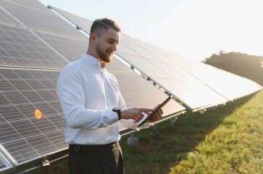 Güneş panellerinin güneşli bir alandaki performansını doğrulayan mühendis, verimliliği ve sürdürülebilir yenilenebilir enerji üretimini sağlıyor
