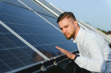 Güneş panellerini denetleyen mühendis, yenilenebilir enerji üretimi ve sürdürülebilir teknoloji geliştirme performansını kontrol ediyor