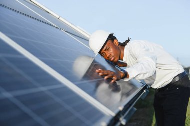 Enerji çiftliğindeki güneş panelini kontrol eden bir mühendis. Sürdürülebilir teknoloji, temiz güç ve çevresel sorumluluğun temsilcisi