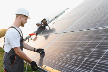 Mühendisler, temiz elektrik üretimi için fotovoltaik paneller yerleştiriyor.