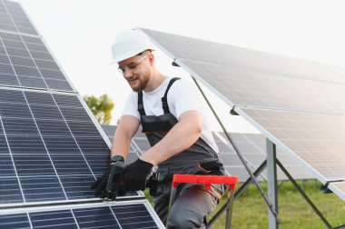 Yeni bir güneş paneli kuran işçiler, güneşli bir günde yeşil enerji üretimine ve sürdürülebilir gelişime katkıda bulunuyor