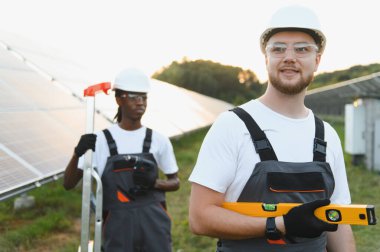 Bir enerji santralinde güneş paneli kurulumunu kontrol eden iki farklı mühendis yenilenebilir enerji üretimi için hassasiyet sağlıyorlar.