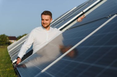 Adam güneş paneli kurulumunu denetliyor, sürdürülebilir yenilenebilir enerji üretiminin verimliliğini sağlıyor