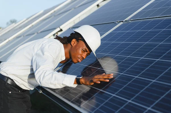Büyük bir güneş çiftliğinde sürdürülebilir ve temiz enerji üretimi sağlayan güneş paneli performansını kontrol eden mühendis