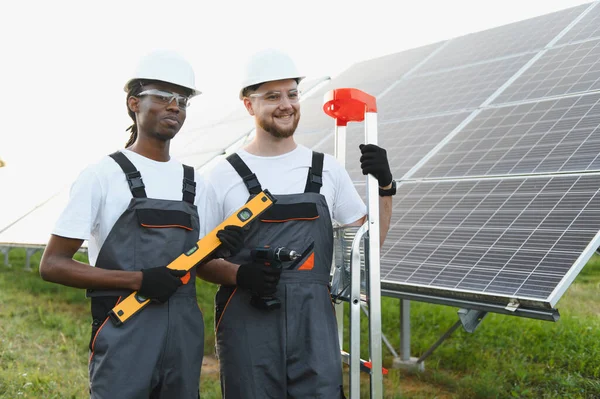 Güneş panelleri kuran, yeşil enerjiye ve sürdürülebilir enerji üretimine katkıda bulunan iki farklı teknisyen