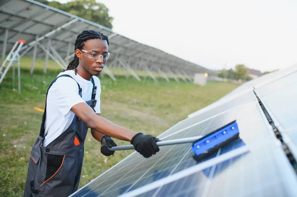 Afrika kökenli Amerikalı işçiler güneş panellerini fırçayla temizliyor ve güneş çiftliklerinde verimli yenilenebilir enerji üretimini sağlıyorlar.