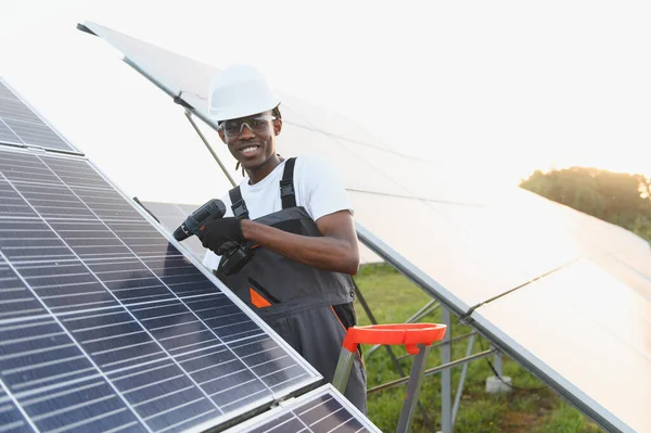 Afrikalı Amerikalı teknisyen fotovoltaik paneller kuruyor, yeşil enerji üretimine ve sürdürülebilir enerji üretimine katkıda bulunuyor