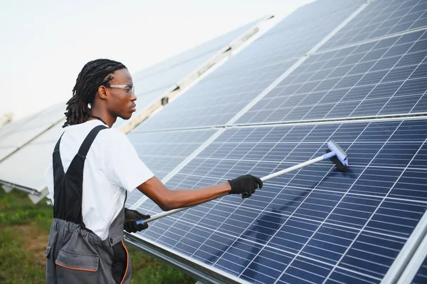 Etkili yeşil enerji üretimi ve sürdürülebilir işlemleri güvence altına alan bir güneş enerjisi santrali kuran Afrikalı Amerikan işçisi