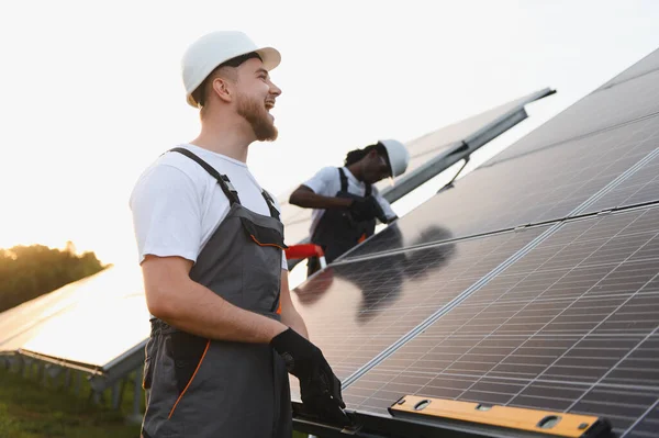 Fotovoltaik panelleri tamir etmeye çalışan adamlar. Sürdürülebilir elektrik üretimi için güneş enerjisi kullanılıyor