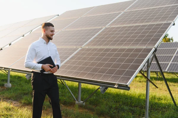 Güneş panellerini denetleyen mühendis çevresel sürdürülebilirlik için yenilenebilir enerji üretimini yönetiyor.