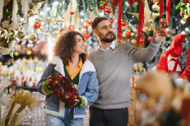 Mutlu çift tatil sezonu için dekoratif eşyalar seçiyor, kışın ve yeni yılın tadını çıkarıyor.