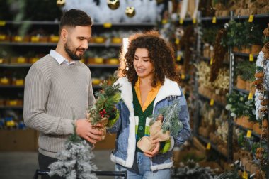 Perakende mağazasında Noel süsleri seçen bir çift tatil sezonuna hazırlanıyor ve birlikte kutluyorlar.