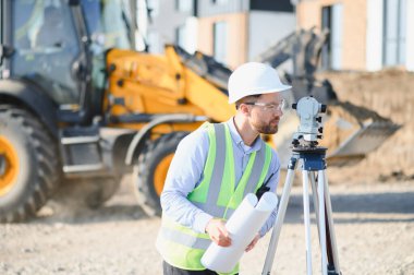 İnşaat alanında çalışan bir arazi mühendisi. Yeni bina inşaatı için ayrıntılı inceleme ve haritalama yapıyor. Planlar tutuluyor