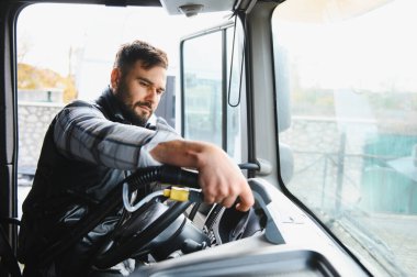 Adam büyük bir taşıma aracı kullanıyor, profesyonel bir teslimatçı olarak çalışırken yola odaklanmış.