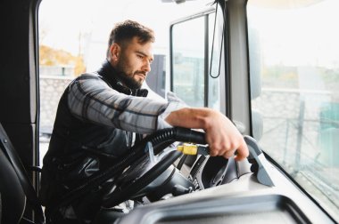 Kamyonun içini süpüren bir adam. Profesyonel sürücü araç hijyeni için düzenli bakım yapıyor.