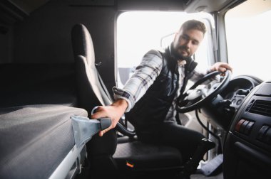 Profesyonel kamyon şoförü iç bakım yapıyor, uzun yolculuklarda hijyen ve konfor için yataklı alanı süpürüyor.