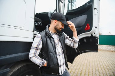 Kamyonetinin yanında duran kendine güvenen sürücü, profesyonel lojistik, ulaşım, meslek ve iş seyahatlerini temsil ediyor.