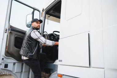 Adam ticari aracına biniyor, lojistik ve ulaşım endüstrisini temsil ediyor. Uzun mesafe başarısı