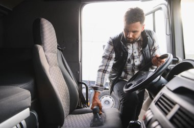 Kamyon kabinini temizleyen adam özel bir elektrikli süpürgeyle temizliyor, hijyen ve profesyonel bakım sağlıyor.