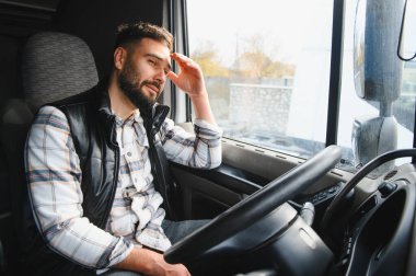 Profesyonel bir adam yorgun ve stresli hissediyor. Kamyon kabininde el ele dinleniyor. İşten yorgun düştüğünü gösteriyor.