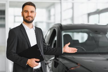 Satıcı el uzatıyor, galeride yeni bir araba teklif ediyor. Profesyonel otomobil işletme hizmetleri tanıtımı