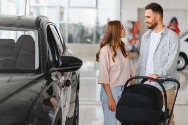 Bebek arabalı genç bir çift yeni bir arabaya bakıyor, aile için önemli bir karar veriyorlar.