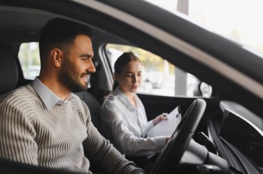Kadın otomobil satıcısı ile erkek test sürüşü, planlama araç alımı ve seçim ile mutlu
