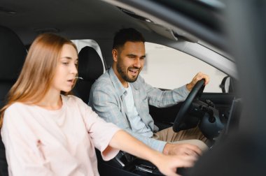 Mutlu çift yeni araba satın almayı düşünüyor, gülümsüyor ve iç mekan hakkında konuşuyor. Birlikte büyük bir satın alma kararı aldık.