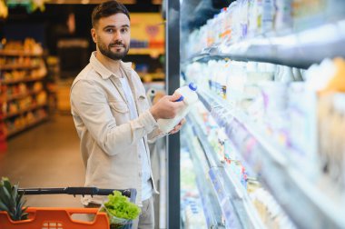 Müşteri alışverişi, dondurulmuş bölümde taze süt bulundurmak, sağlıklı bir seçim yapmak.