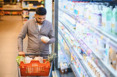 Market alışverişi, alışveriş arabası, dondurulmuş süt ürünlerini incelerken...