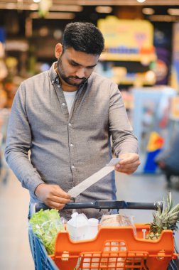 Adam, enflasyon süresince market fişini, harcamaları ve bütçeyi gözden geçiriyor.