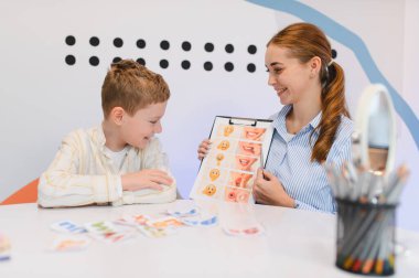 Konuşma terapisti, ağız şekilleri ve duygular için görsel araçlar kullanarak konuşma ve konuşma gelişimine yardımcı oluyor.