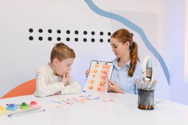 Terapi sırasında görsel yardımlar kullanarak çocuk iletişimi egzersizleri öğreten uzman, konuşma gelişimine odaklanıyor