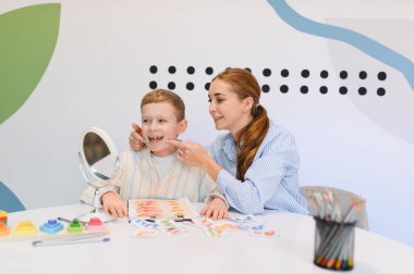 Konuşma terapisti, terapi seanslarında ayna ve görsel araçlar kullanarak konuşma becerilerini geliştirmeyi öğretiyor.