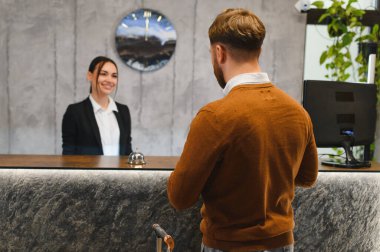 Modern otele konuk geliyor, konukseverliğin ve profesyonel hizmetin tadını çıkarıyor.