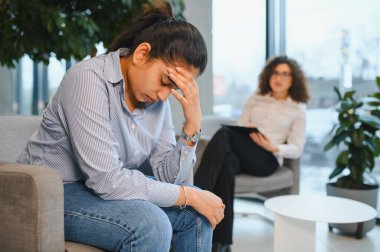 Genç Hintli kadın stres ve akıl sağlığı sorunları yaşıyor, seans sırasında bir kadın psikologdan destek ve danışmanlık alıyor.