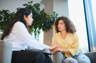 Hintli psikolog genç bir kadına rahatlık ve danışmanlık sağlıyor, zihinsel sağlık ve duygusal refah üzerine odaklanıyor.