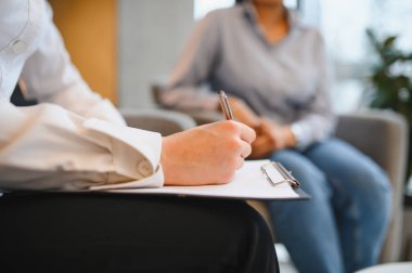 Psikologlar panoya el yazısıyla yazı yazarak Hintli bir kadınla akıl sağlığı desteği sağlıyorlar.