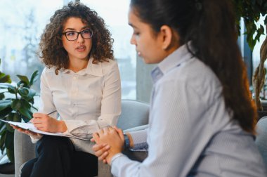 Psikolog, Hintli bir kadın hastaya akıl sağlığı ve tedavi hakkında destek veriyor ve danışmanlık yapıyor.