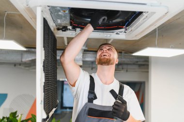 Ticari soğutma sistemi kuran ya da hizmet veren mutlu mühendis, kapalı alan iklimi ve hava kalitesini güvence altına alıyor