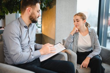 Erkek psikoloğu dinleyen genç bir kadın profesyonel danışmanlık hizmeti veriyor. Ruhsal sağlığa ve duygusal sağlığa profesyonel destek