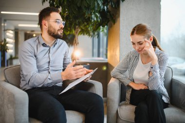 Psikolog terapi seansı sırasında genç bir kadın hastayla tartışıyor, akıl sağlığı ve destek üzerine yoğunlaşıyor.